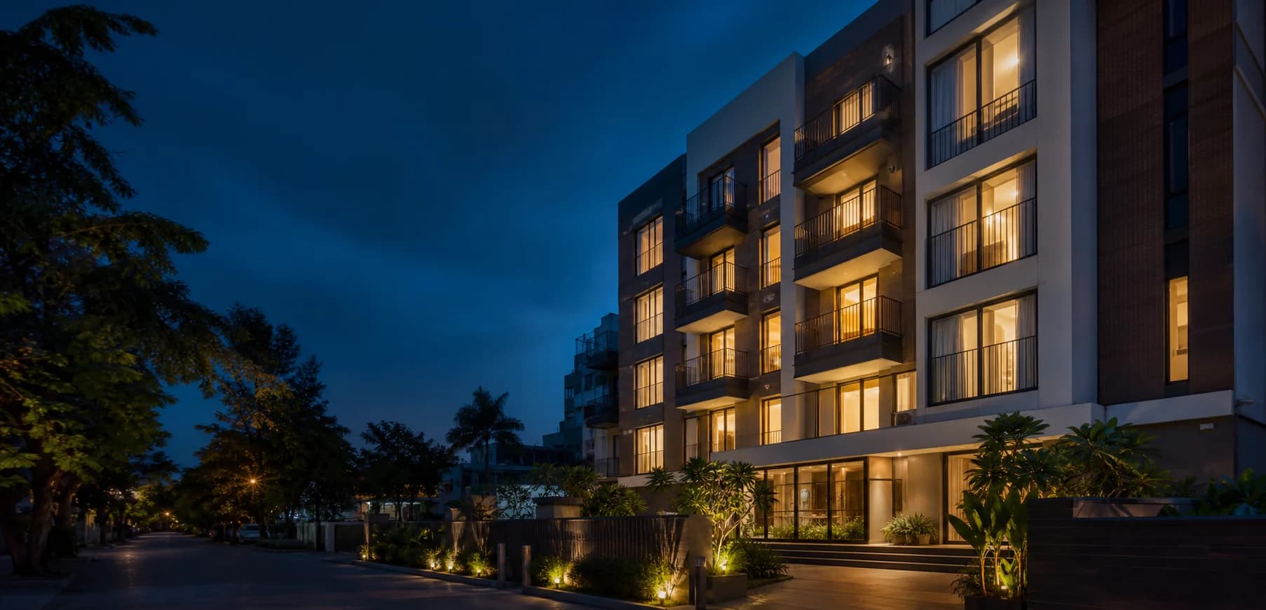 A contemporary co-living residence illuminated at dusk in Pune